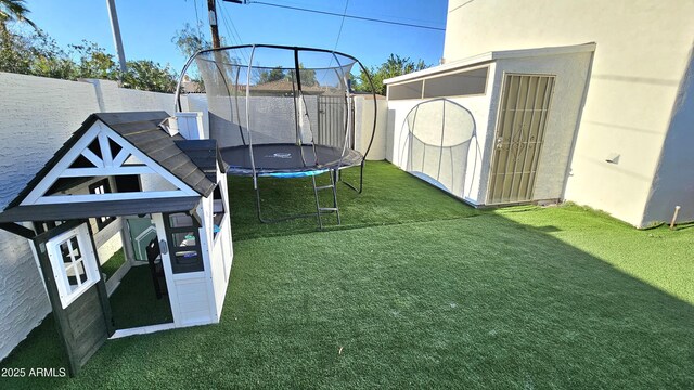 1520 W Encanto Blvd, Phoenix, AZ 85007 - view of yard featuring a fenced backyard, an outbuilding, a shed, and a trampoline