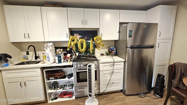 1520 W Encanto Blvd, Phoenix, AZ 85007 - kitchen with white cabinets, light wood-style flooring, a sink, light countertops, and appliances with stainless steel finishes