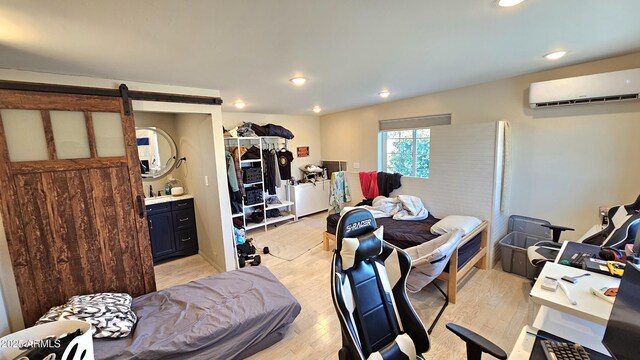 1520 W Encanto Blvd, Phoenix, AZ 85007 - bedroom featuring a barn door, a wall mounted AC, light wood-style flooring, and recessed lighting