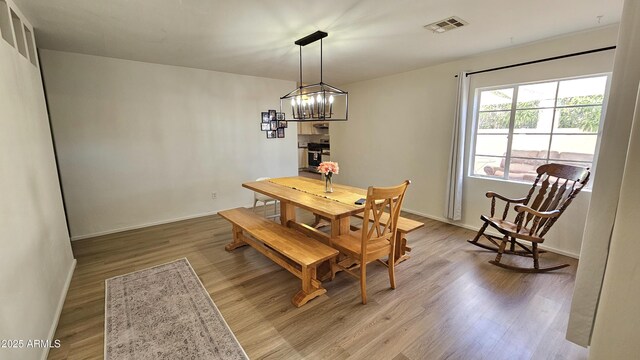 1520 W Encanto Blvd, Phoenix, AZ 85007 - dining area with visible vents, light wood finished floors, baseboards, and an inviting chandelier
