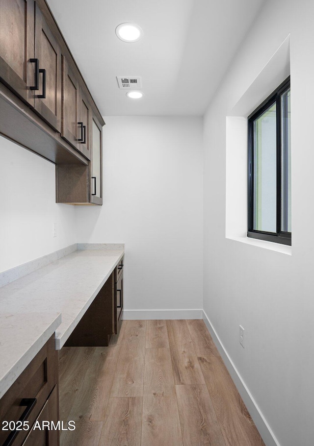 interior space with visible vents, light wood-style flooring, and baseboards