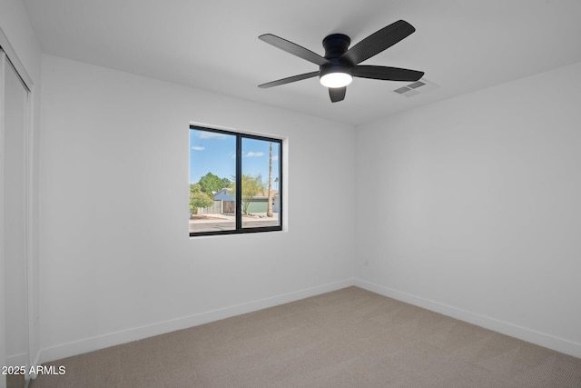 unfurnished room with light carpet, visible vents, a ceiling fan, and baseboards