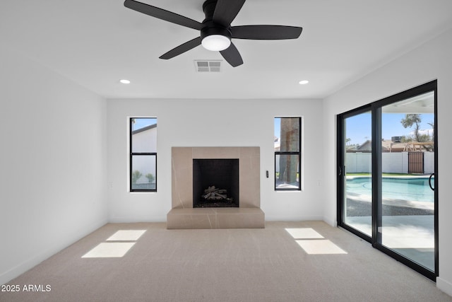 unfurnished living room featuring recessed lighting, a fireplace with raised hearth, visible vents, and carpet floors