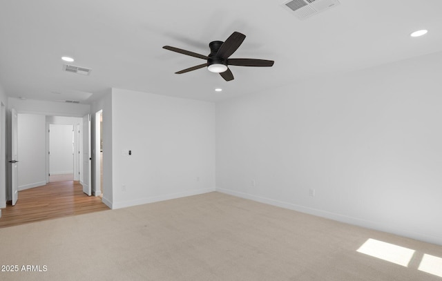 unfurnished room with visible vents, recessed lighting, light colored carpet, and baseboards