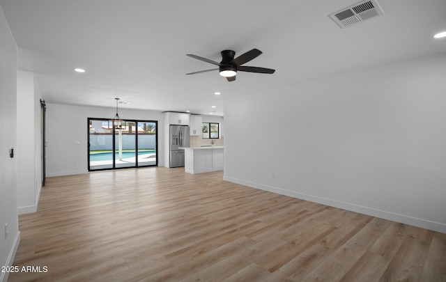 unfurnished living room with recessed lighting, visible vents, light wood-style flooring, and baseboards