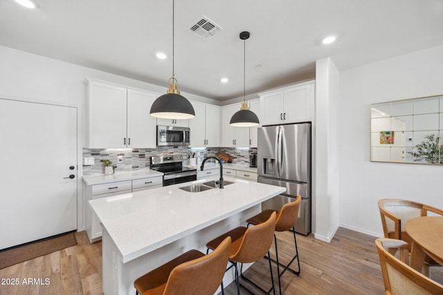 2628 S Voyager Dr Unit 104, Gilbert, AZ 85295 - kitchen with appliances with stainless steel finishes, a sink, decorative backsplash, light wood-type flooring, and recessed lighting