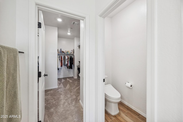 2628 S Voyager Dr Unit 104, Gilbert, AZ 85295 - bathroom featuring toilet, baseboards, a spacious closet, and wood finished floors