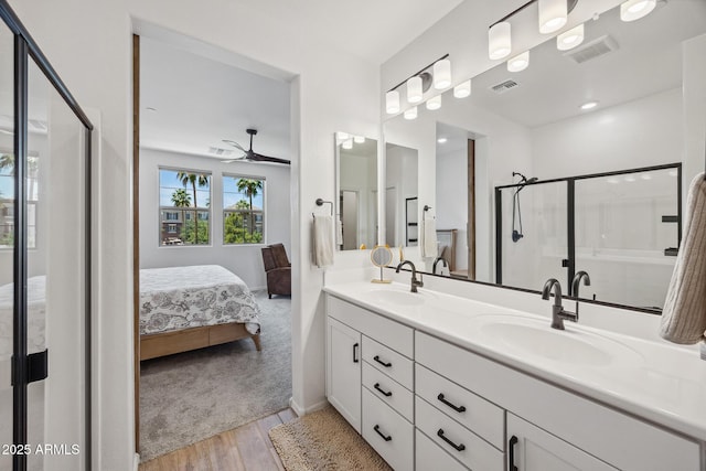 2628 S Voyager Dr Unit 104, Gilbert, AZ 85295 - full bath featuring connected bathroom, wood finished floors, double vanity, a shower stall, and ceiling fan