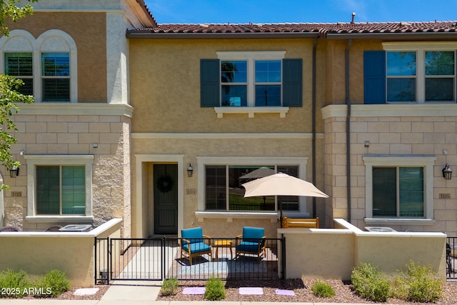 2628 S Voyager Dr Unit 104, Gilbert, AZ 85295 - view of front of house with a fenced front yard, stucco siding, and a gate