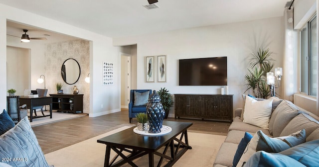 living room featuring wood-type flooring, ceiling fan, and a wealth of natural light