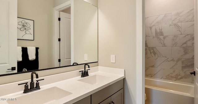 bathroom with tiled shower / bath combo and dual vanity