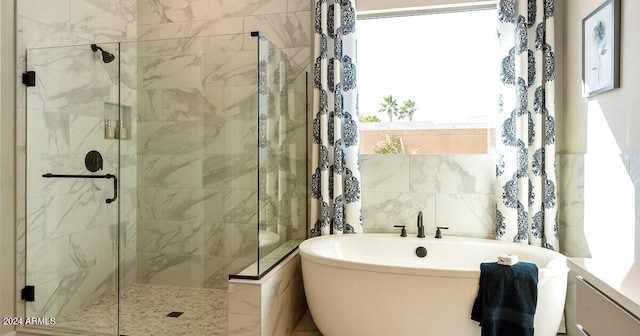 bathroom featuring tile walls and independent shower and bath