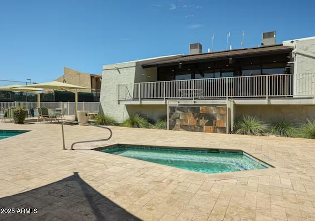 pool with fence, a patio, and a hot tub