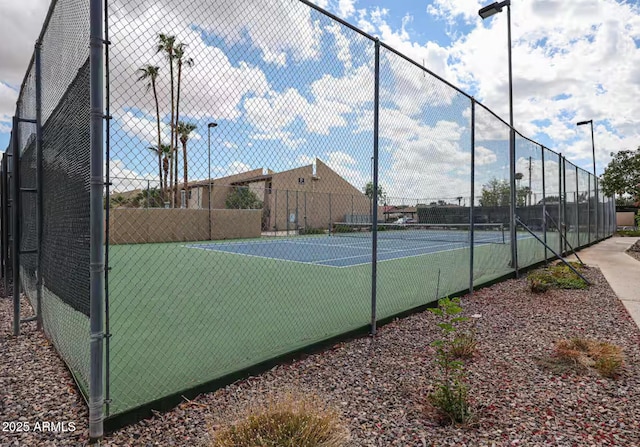 view of tennis court featuring fence