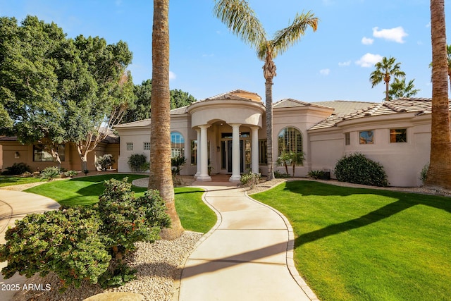 mediterranean / spanish-style house featuring a front yard, a tile roof, and stucco siding