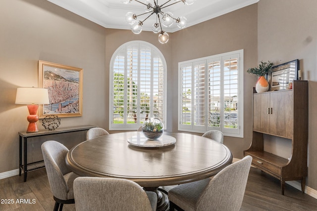 dining area with baseboards, dark wood-type flooring, crown molding, and an inviting chandelier