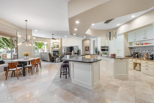 kitchen featuring dark countertops, a spacious island, pendant lighting, and open floor plan