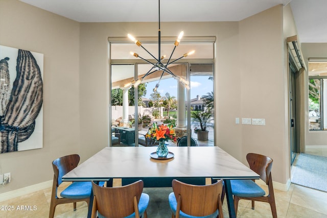 dining area with a notable chandelier, plenty of natural light, baseboards, and light tile patterned flooring