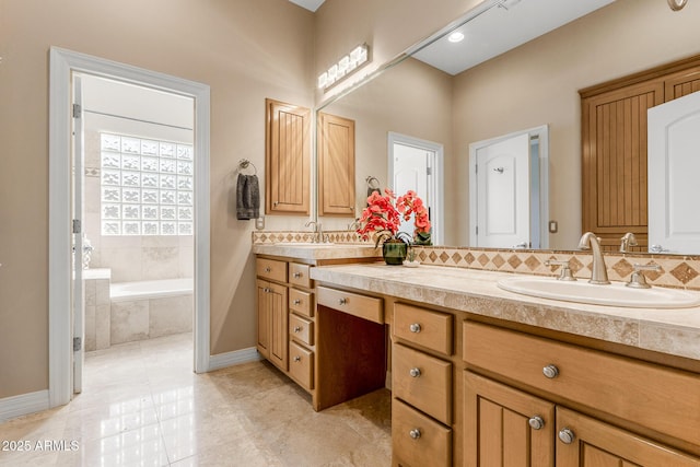 full bath featuring double vanity, decorative backsplash, tile patterned floors, a garden tub, and a sink