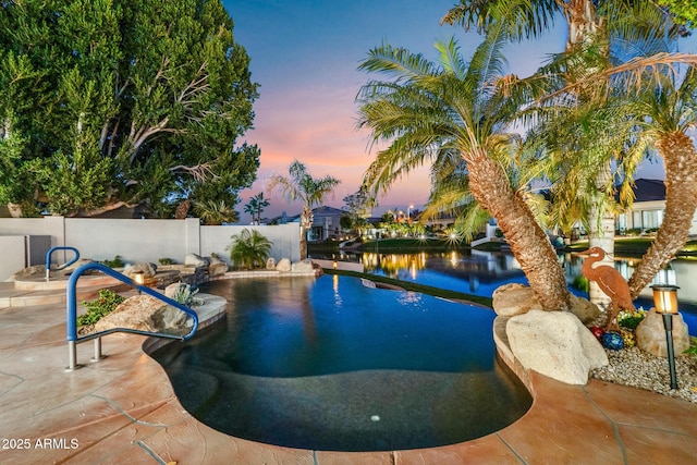 pool at dusk with a patio area, fence, and a fenced in pool