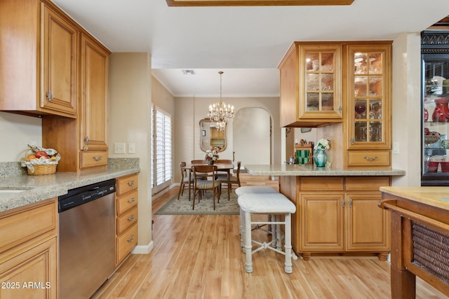 kitchen with light stone counters, light wood-style flooring, a notable chandelier, dishwasher, and glass insert cabinets