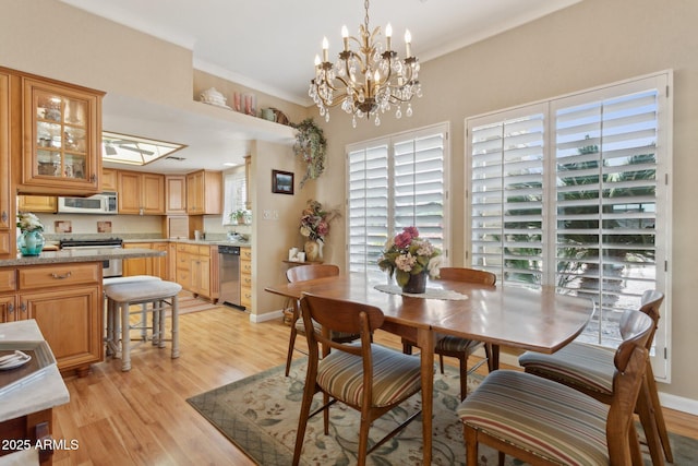 dining space with crown molding, light wood-style flooring, and baseboards