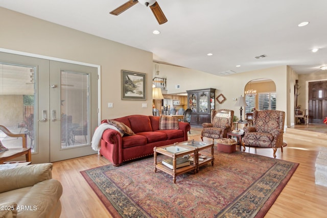 living room with arched walkways, recessed lighting, visible vents, french doors, and light wood finished floors