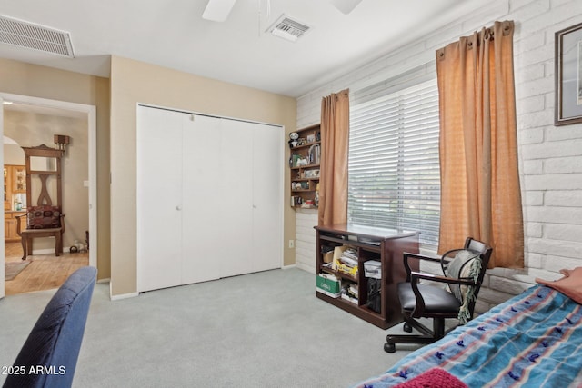 bedroom featuring a closet, visible vents, and brick wall