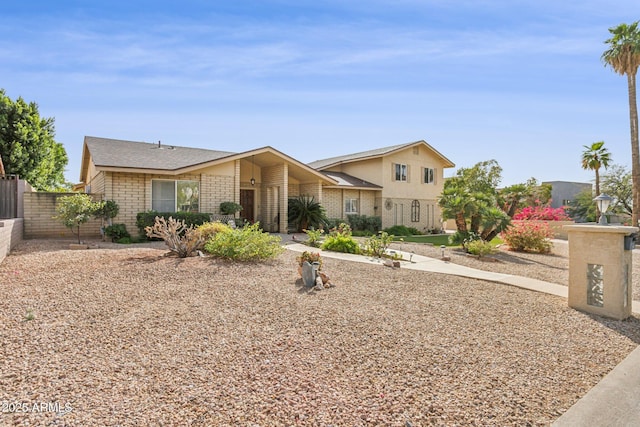 mid-century modern home with brick siding and fence