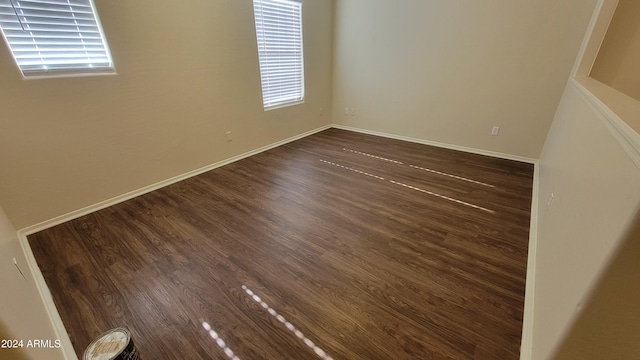 unfurnished room with dark hardwood / wood-style flooring