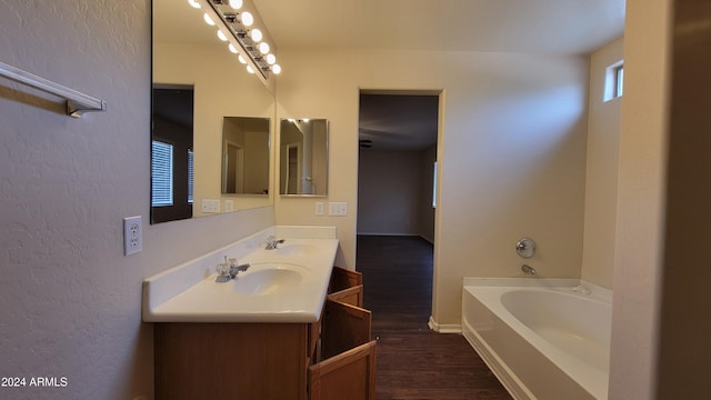 bathroom featuring a washtub, hardwood / wood-style flooring, and vanity