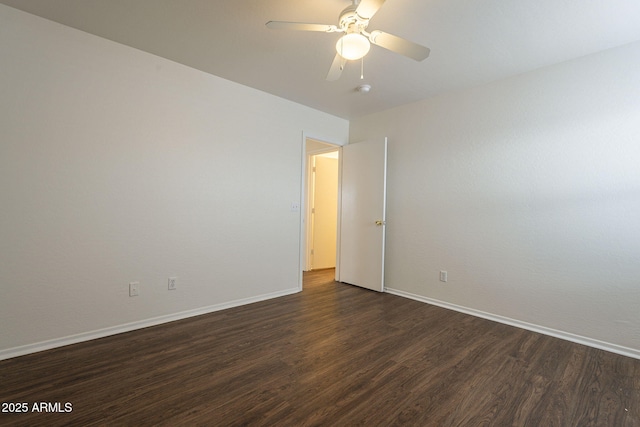 spare room featuring ceiling fan and dark wood-type flooring