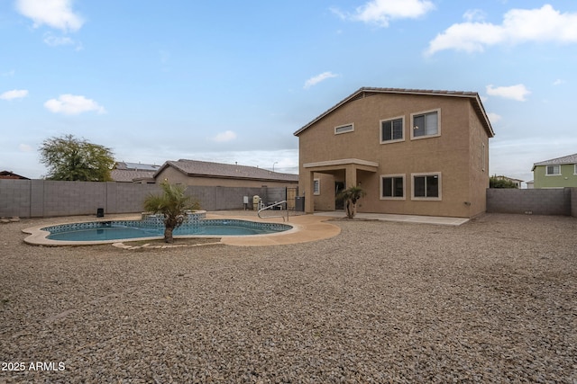 back of property featuring a patio area and a fenced in pool