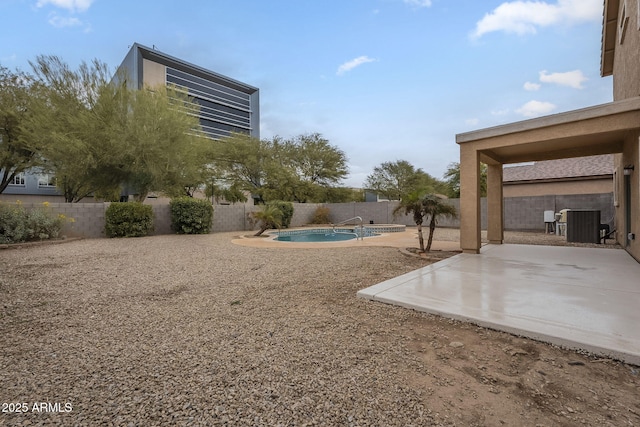 view of yard featuring a patio, a fenced in pool, and central AC