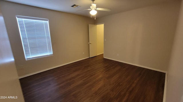 empty room featuring ceiling fan and dark wood-type flooring