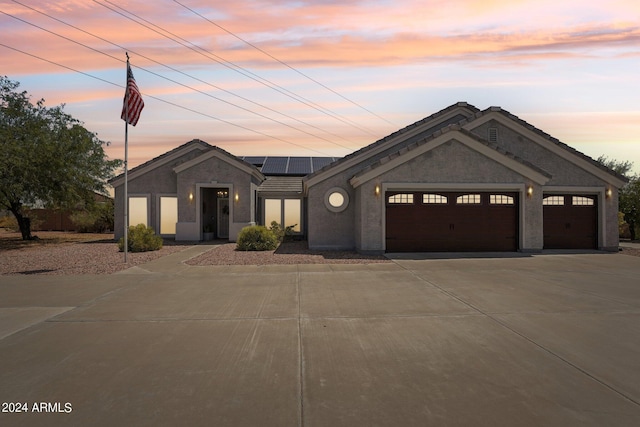 view of front of home featuring a garage and solar panels