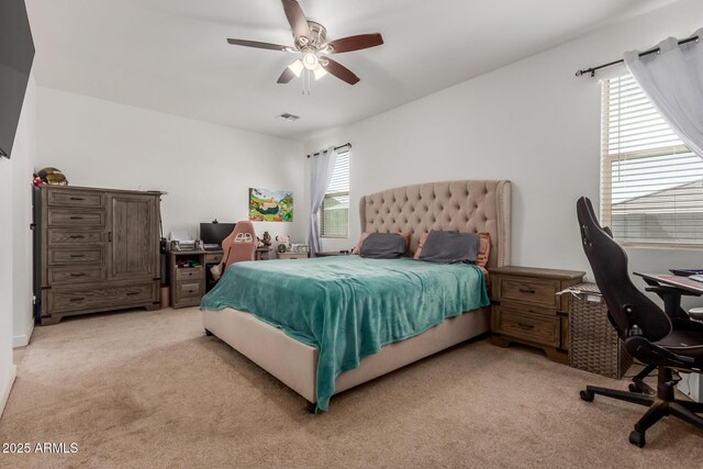 bedroom with visible vents, ceiling fan, and light colored carpet