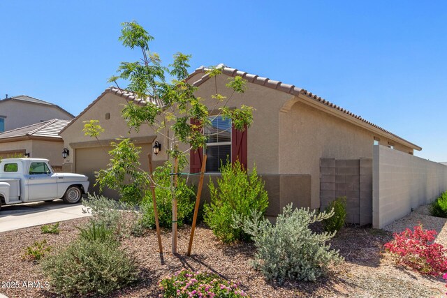 view of front of house featuring a garage, stucco siding, and a tiled roof