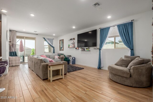 living area with recessed lighting, baseboards, visible vents, and light wood-type flooring