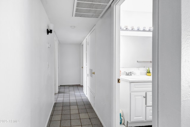 3222 W Hearn Rd, Phoenix, AZ 85053 - hall with dark tile patterned flooring, baseboards, visible vents, and a sink