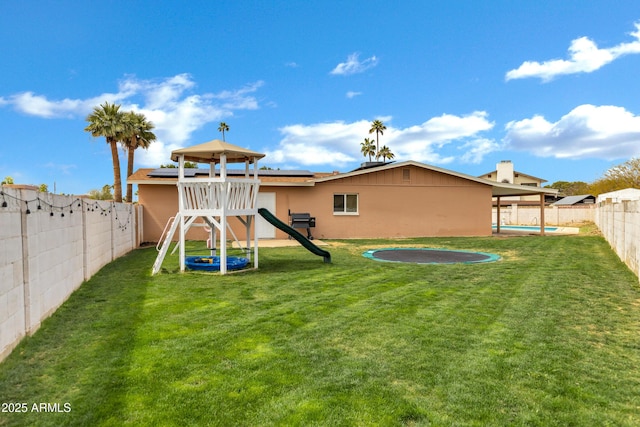 3222 W Hearn Rd, Phoenix, AZ 85053 - rear view of house featuring a lawn, roof mounted solar panels, a fenced backyard, a playground, and a fenced in pool