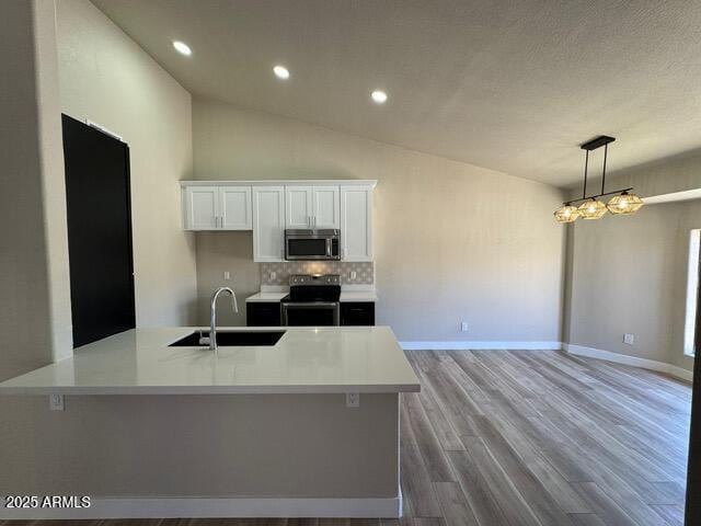 5236 W Peoria Ave Unit 232, Glendale, AZ 85302 - kitchen with appliances with stainless steel finishes, white cabinetry, light countertops, wood finished floors, and decorative backsplash