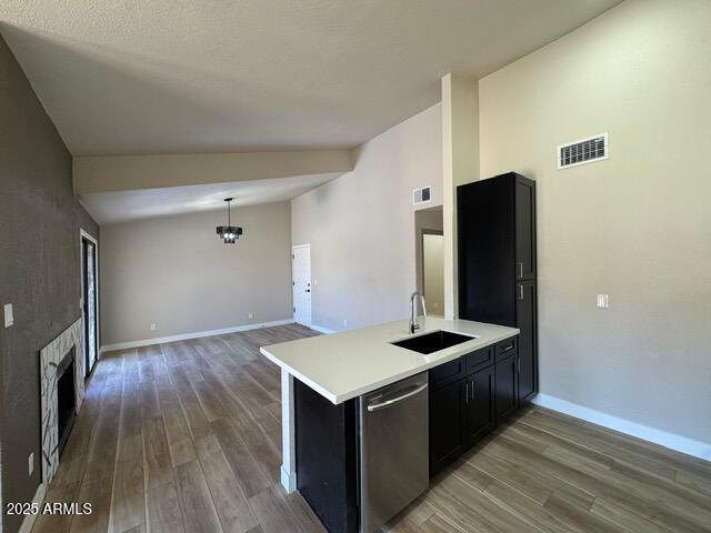 5236 W Peoria Ave Unit 232, Glendale, AZ 85302 - kitchen with stainless steel dishwasher, wood finished floors, lofted ceiling, light countertops, and dark cabinetry