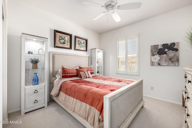 bedroom featuring light colored carpet, a ceiling fan, and baseboards