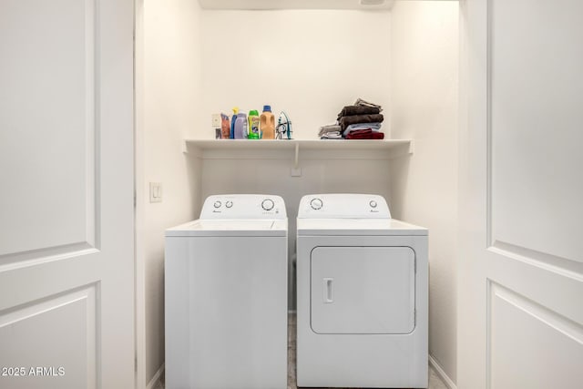 clothes washing area with baseboards, laundry area, and washing machine and clothes dryer