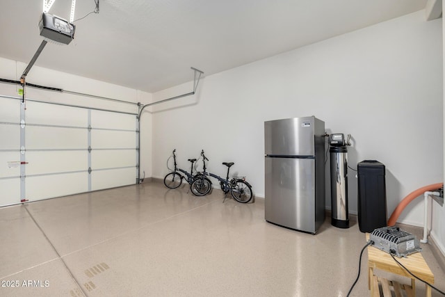 garage featuring freestanding refrigerator and a garage door opener