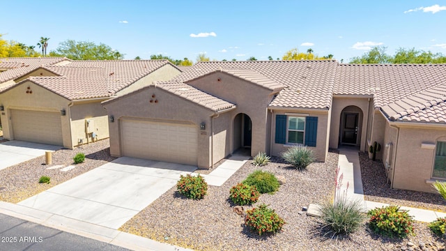 view of front of house featuring a garage, stucco siding, a tiled roof, and driveway