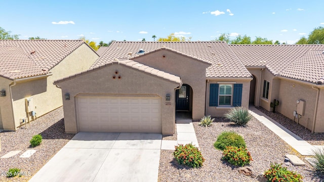 view of front facade featuring concrete driveway, stucco siding, an attached garage, and a tiled roof