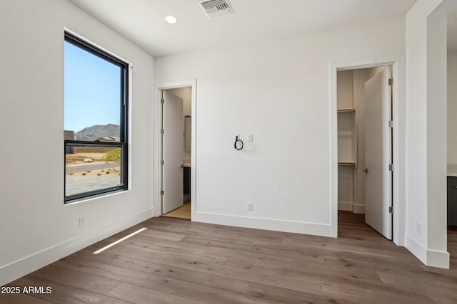 13278 E Buckskin Trl, Scottsdale, AZ 85255 - unfurnished bedroom featuring a walk in closet, wood finished floors, baseboards, recessed lighting, and connected bathroom