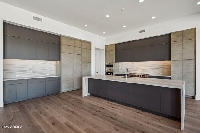 13278 E Buckskin Trl, Scottsdale, AZ 85255 - kitchen with modern cabinets, a spacious island, wood finished floors, light countertops, and a sink